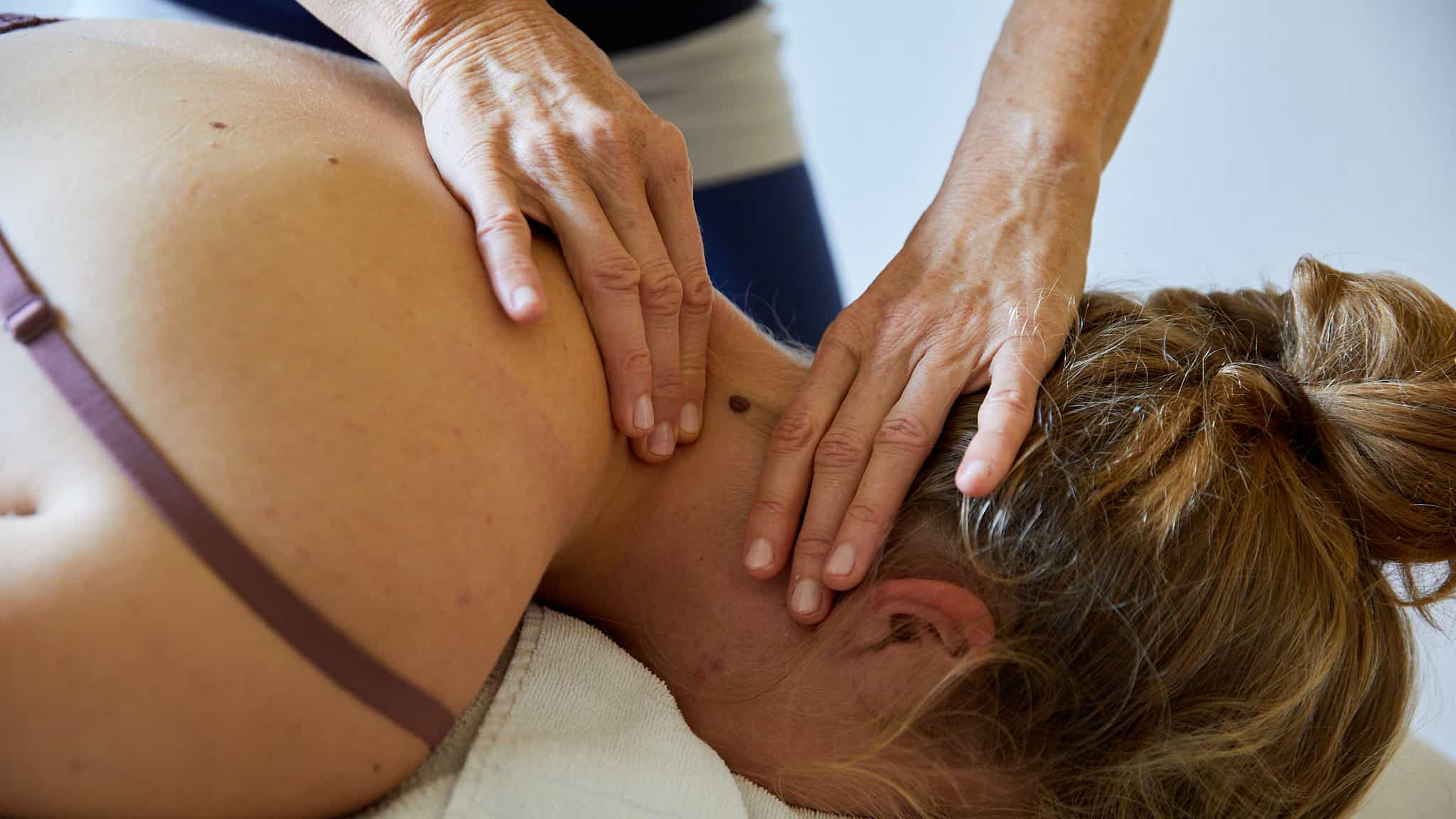 Behandlung am Hals mit einer medizinischen Massage. Klientin liegt in Bauchlage. Damit kann eine Dauerspannung aufgelöst werden.